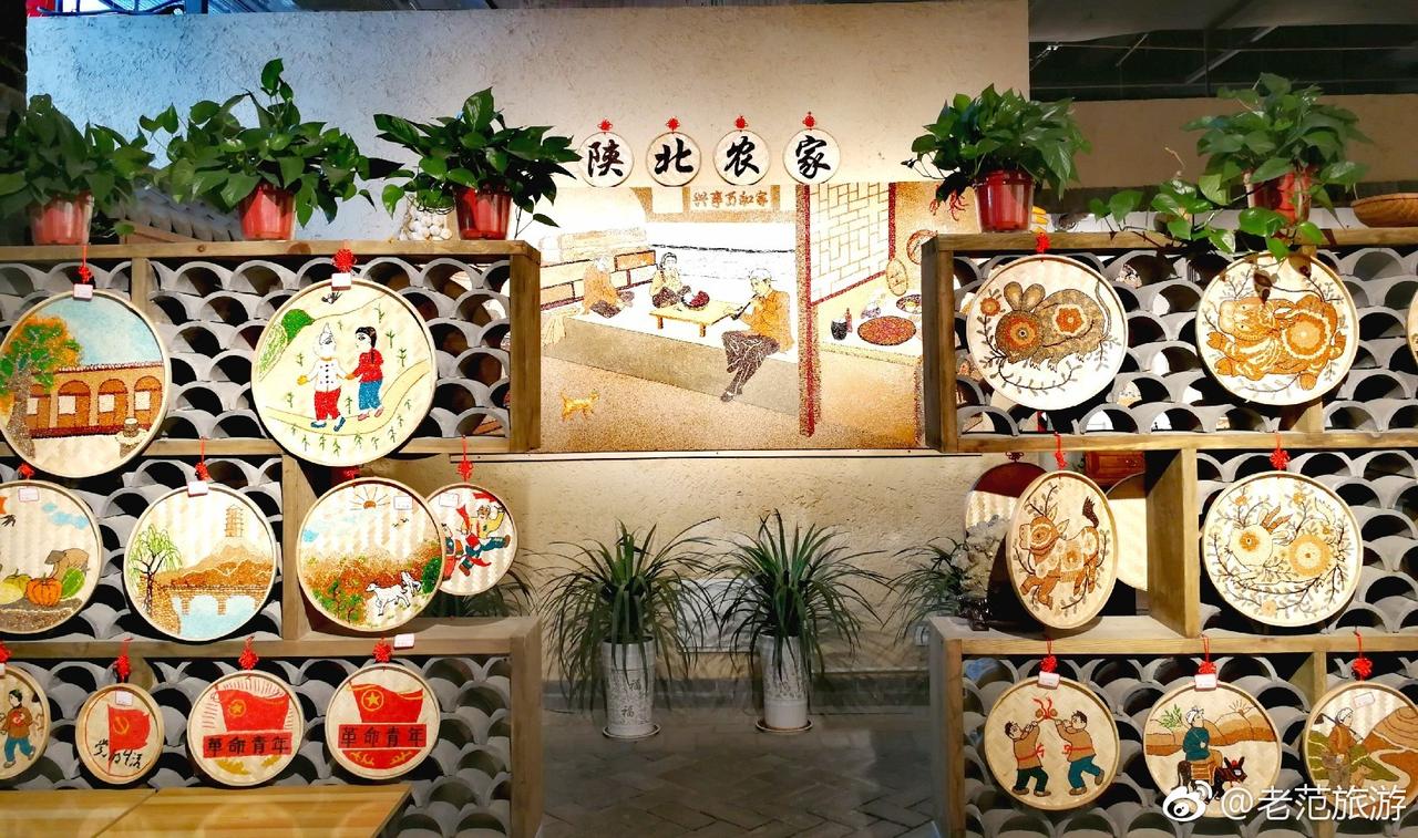 延安1938街区餐饮区内部，墙上装饰有陕北农家和革命主题壁画