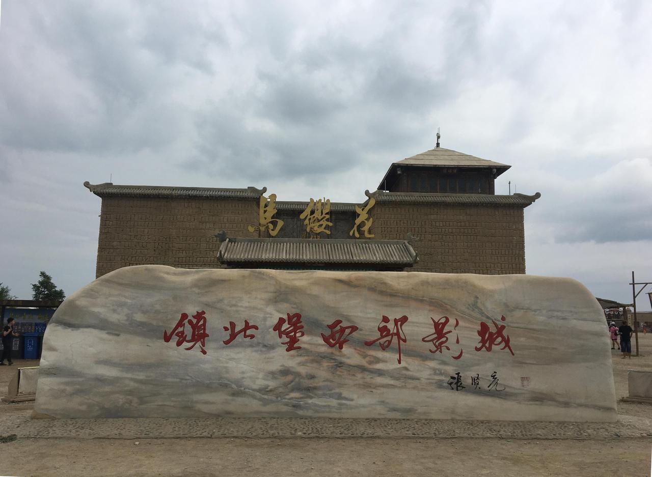 A traditional-style watchtower and a section of rammed earth city walls are visi