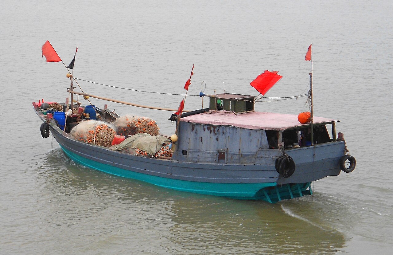 洞庭湖上一艘小型机动渔船，船体停泊在湖岸附近