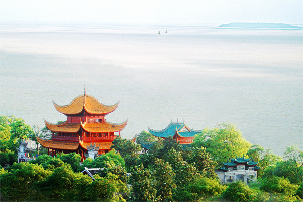 岳阳楼侧影，黄色琉璃瓦的盔顶轮廓在洞庭湖背景下清晰可见