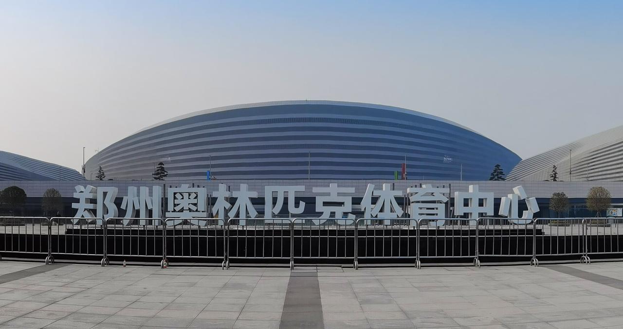 郑州奥体中心外景，弧形银白色罩棚和玻璃幕墙
