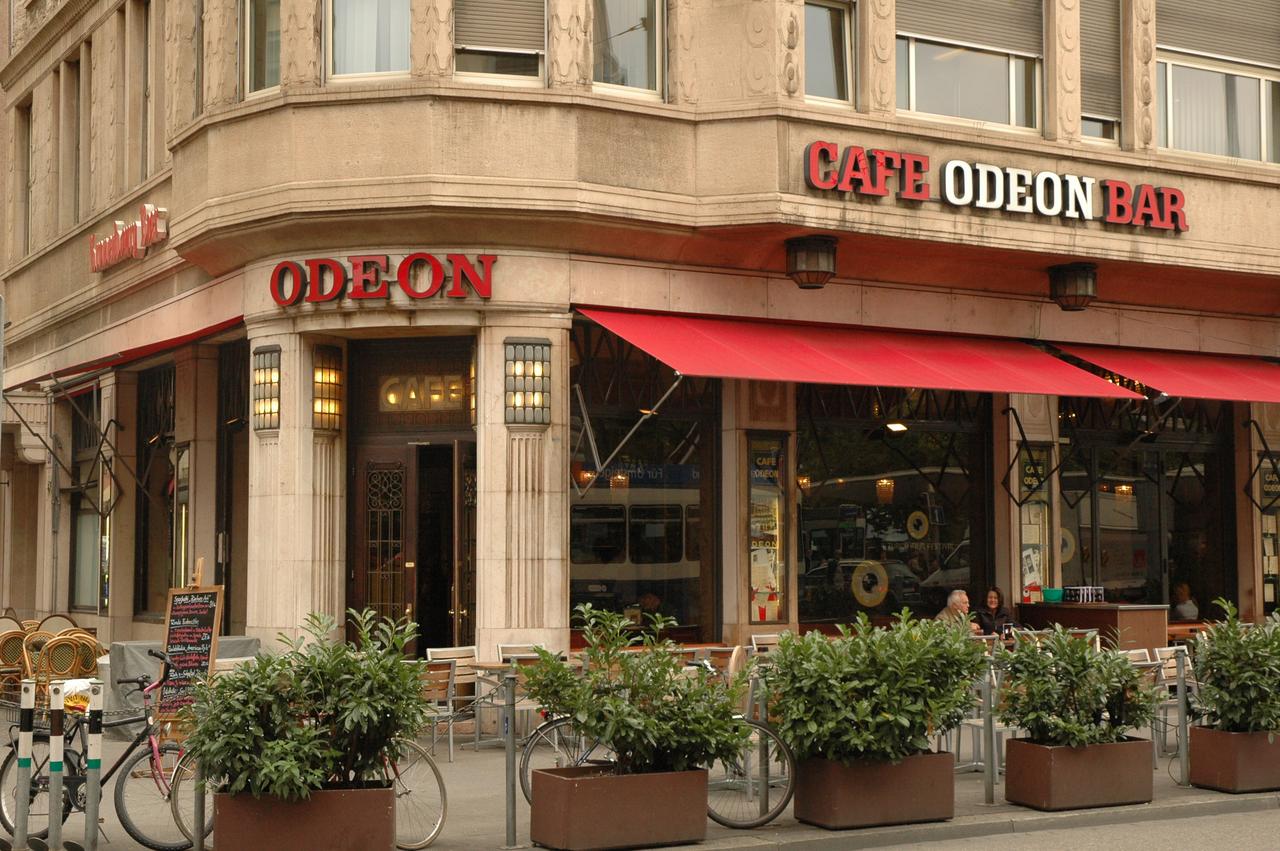 Café Bar Odeon 外立面正面，可见大窗户与露天座位